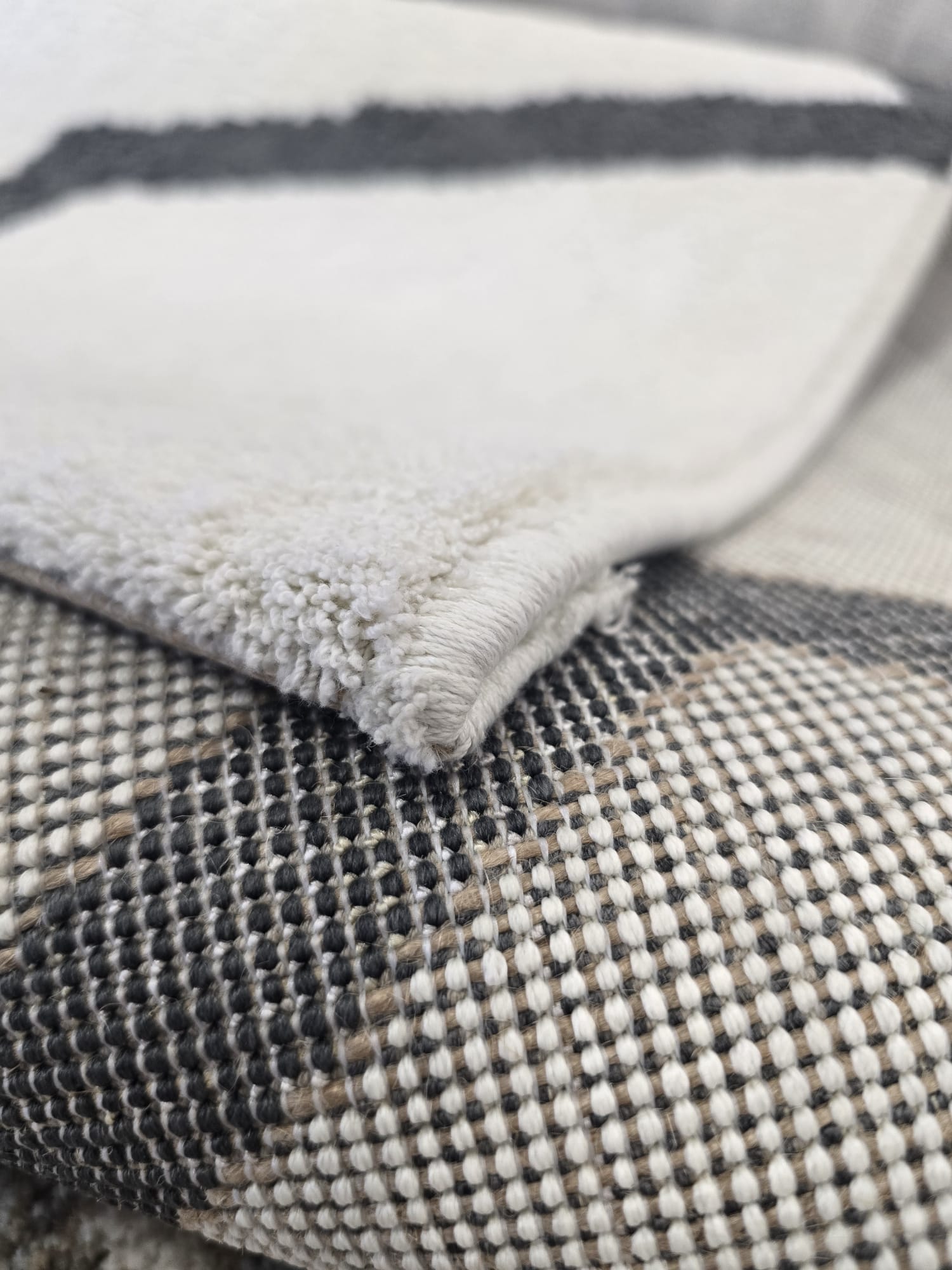 Tepih HEXA moderni svijetli tepih s tamnosivim geometrijskim linijama, izrađen od 100% poliestera, s mekanim florom od 11 mm.