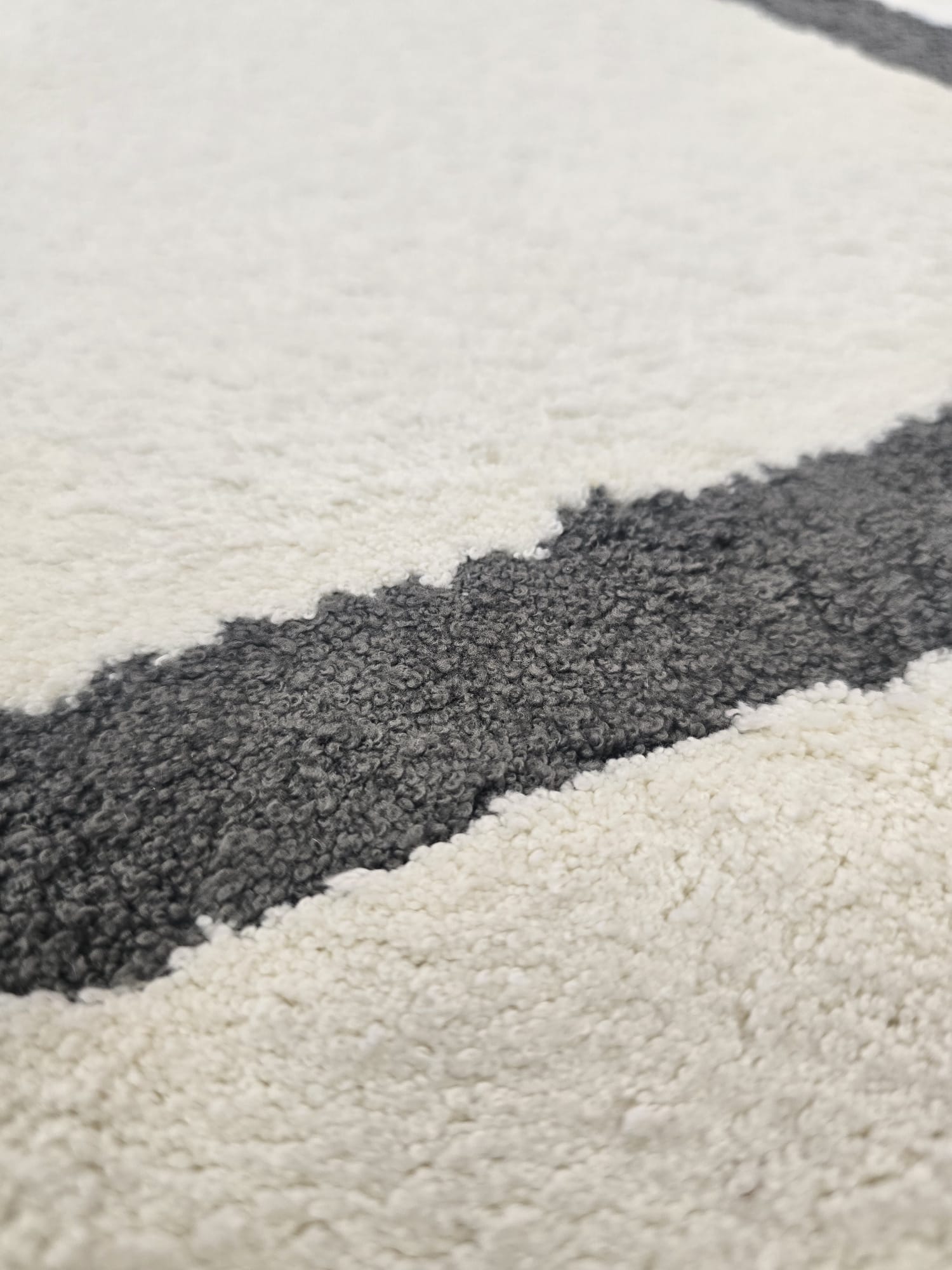 Tepih HEXA moderni svijetli tepih s tamnosivim geometrijskim linijama, izrađen od 100% poliestera, s mekanim florom od 11 mm.