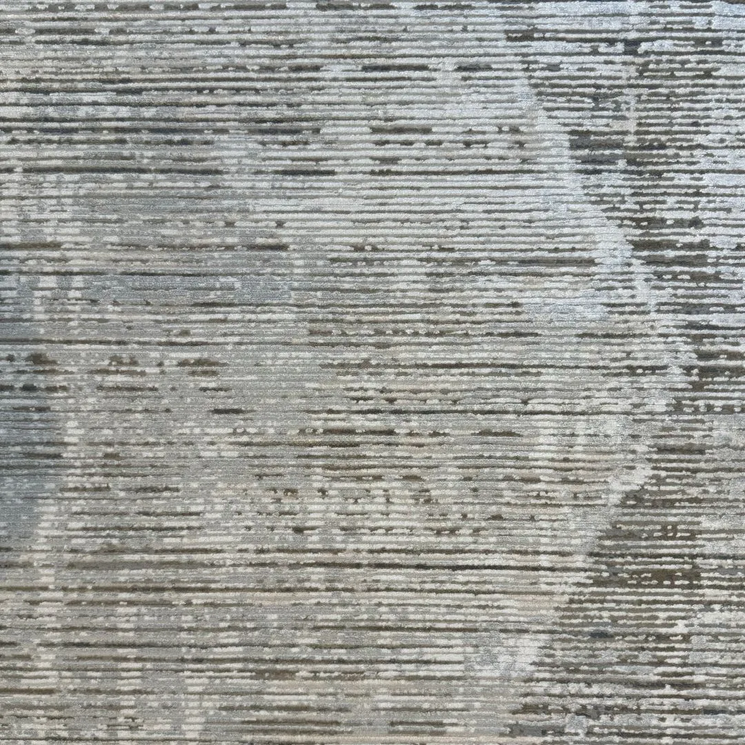 Tepih URBAN u maslinasto sivim, krem i grafitnim tonovima, s apstraktnom patiniranom površinom, bambusovom svilom (viskozom), akrilom i profinjenom igrom svjetla.