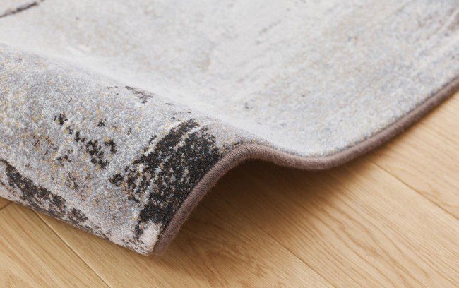 Tepih GENT PELIN moderni apstraktni tepih u smeđim, sivim, bež, ivory i tamnim tonovima, izrađen od 100% PP Heatset materijala s teksturiranom površinom.