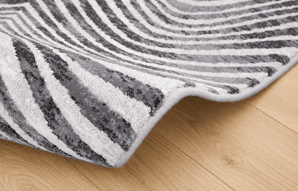 Tepih Gent ZEBRA moderni crno bijeli tepih s valovitim zebra prugama, sivim detaljima i teksturiranom površinom od 100% PP Heatset materijala.