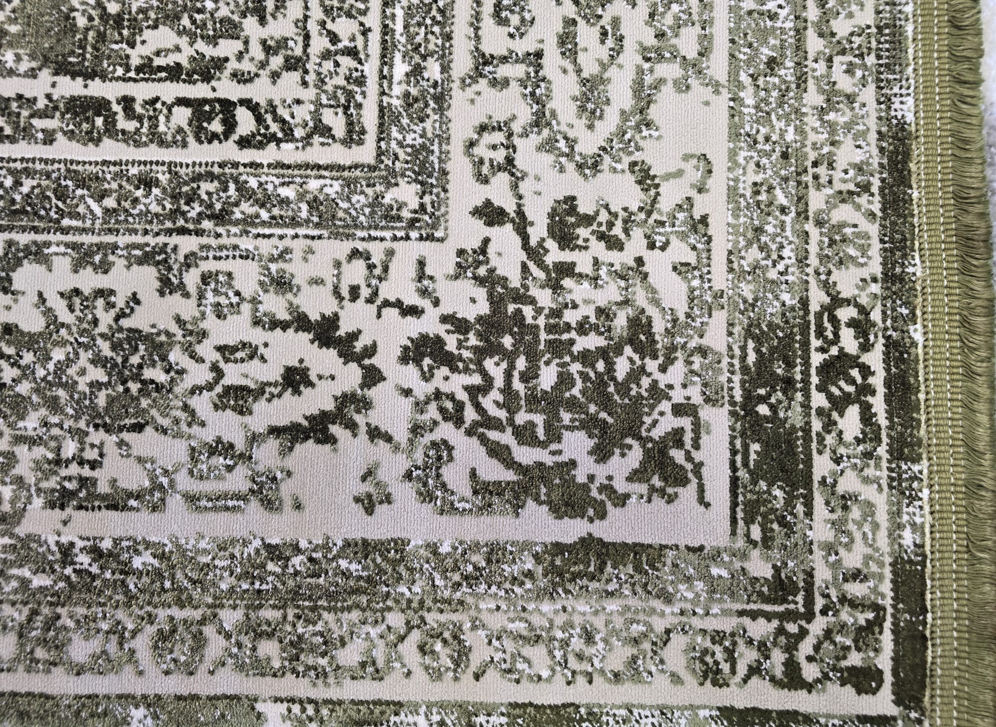Tepih Pierre Cardin Elysée 902 Green luksuzni zeleno-sivi vintage tepih s ornamentom i bordurom, izrađen od Lyocella, viskoze i akrila, s mekanim florom i 3D efektom.