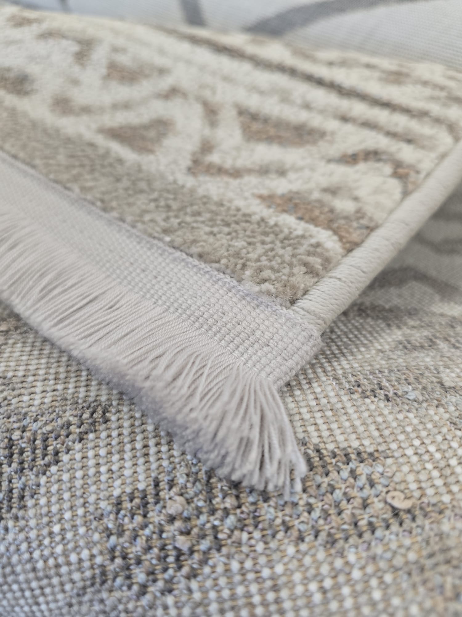 Tepih LIRIA donosi nježan vintage izgled u bež, sivim, pastelno plavim i ljubičastim tonovima. Izrađen je od 100% PP, odnosno 100% polipropilena, praktičnog materijala za svakodnevno korištenje i jednostavno održavanje. Heatset obrada daje vlaknu ugodniji dodir i stabilniji izgled površine. Visina flora od 8 mm stvara elegantan niži profil, dok ukupna masa od 2.278 g/m² daje stabilniji dojam na podu. Resice na kraćim stranama dodatno naglašavaju mekan, tekstilan i profinjen vintage karakter.