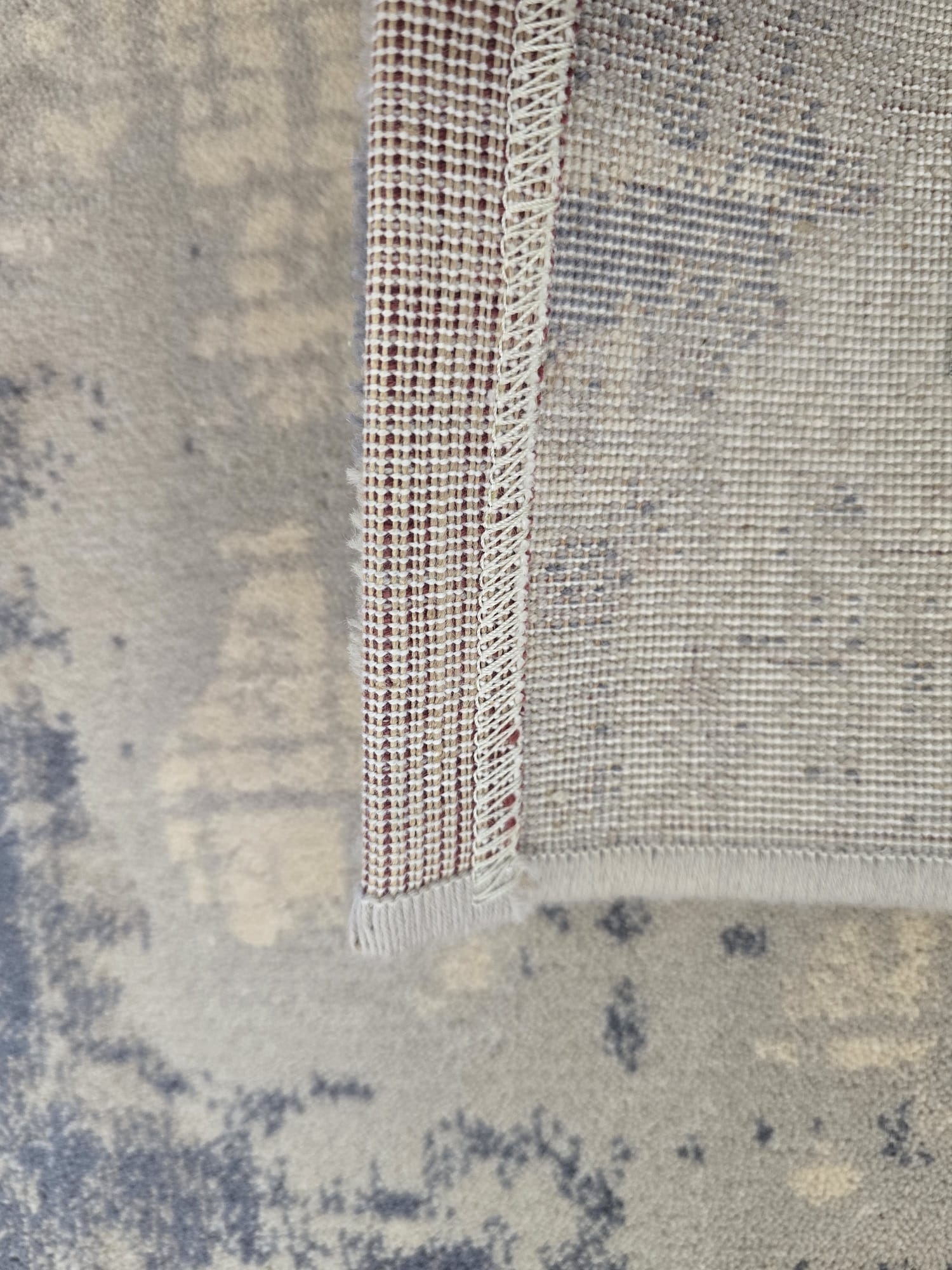 Vuneni Tepih Blu moderni vintage tepih u plavim, ivory, bež i sivim tonovima, izrađen od 100% prirodne vune, s mekanom baršunastom površinom.